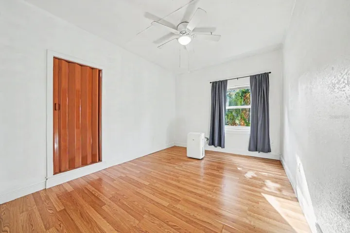 Bedroom with Hardwood Floors, Ceiling Fan & Window with Landscape Views