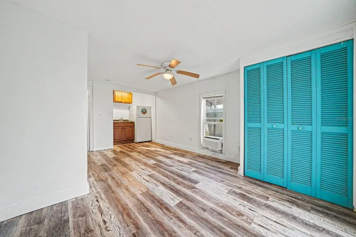 Bright Bedroom with Turquoise Closets, Wood Floors & Multiple Windows