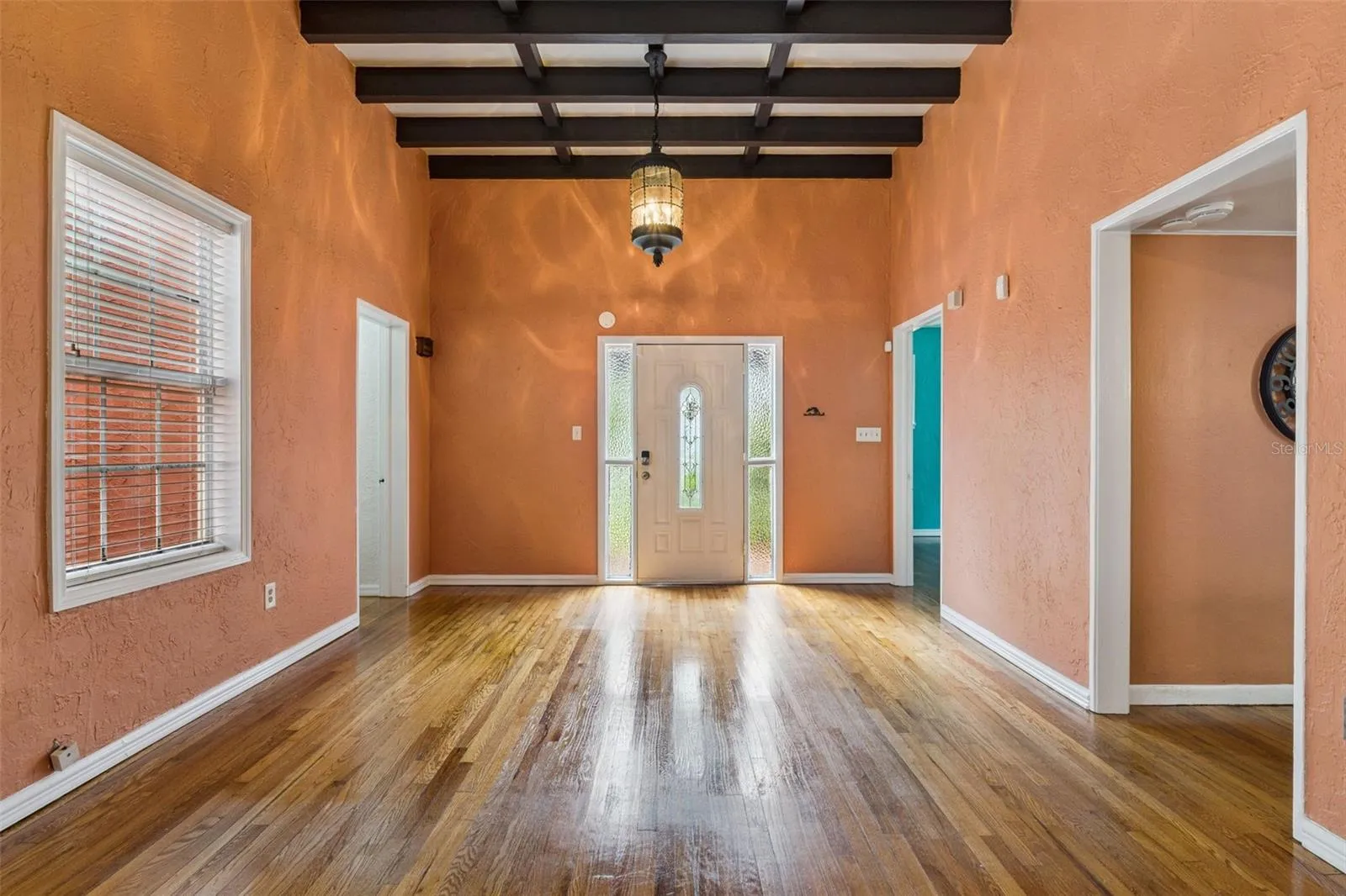 An inviting living room connects the home’s spaces beneath beautiful beamed ceilings