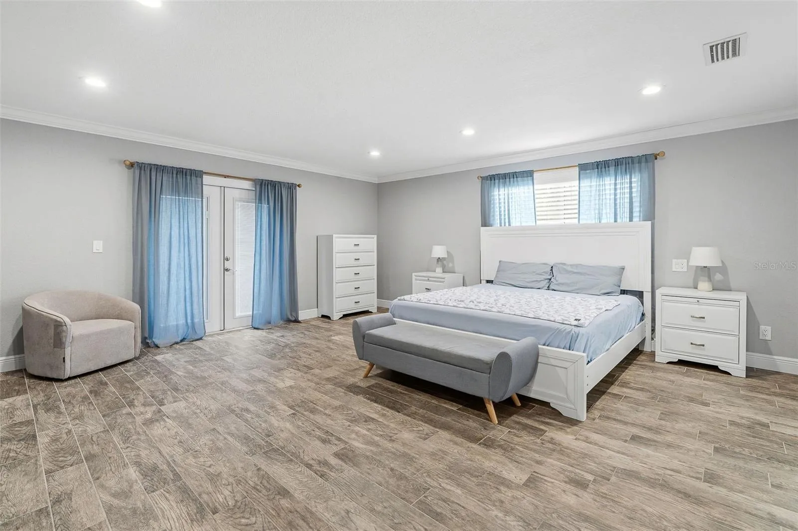 Primary bedroom with French doors to patio and pool.