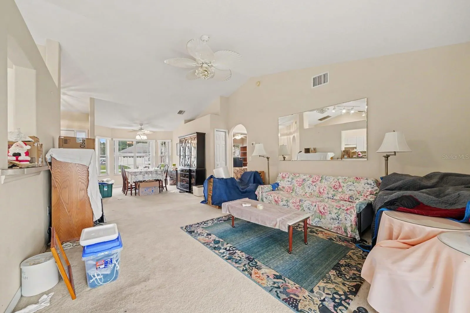 Open-concept great room with high ceilings, multiple windows, and seamless flow