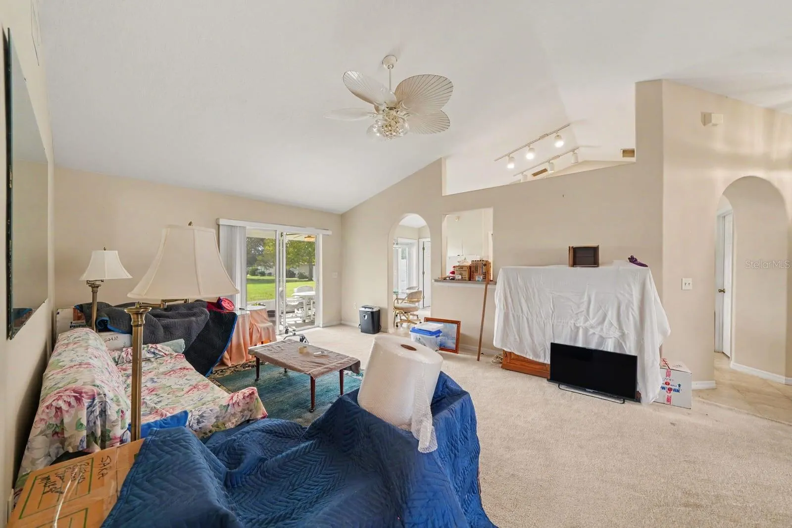 Expansive living area with vaulted ceilings, glass doors, and open room layout