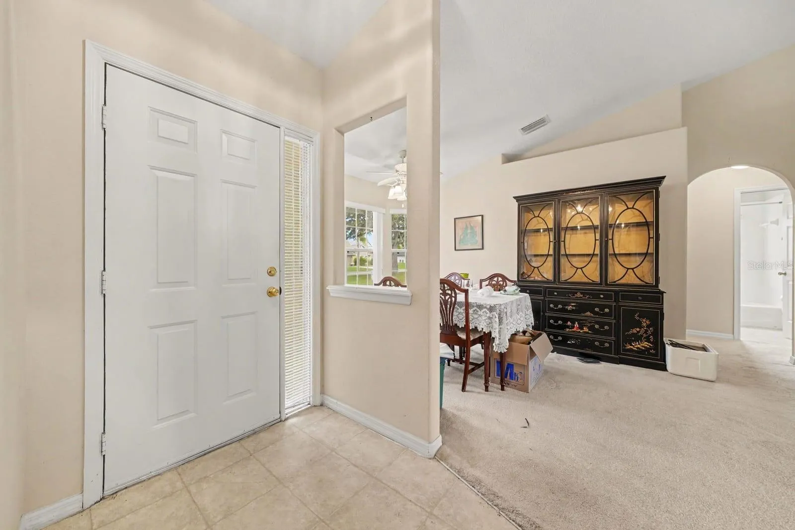 Spacious garage entry with closet access and tile flooring leading to home interior