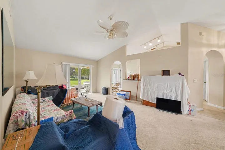 Expansive living area with vaulted ceilings, glass doors, and open room layout