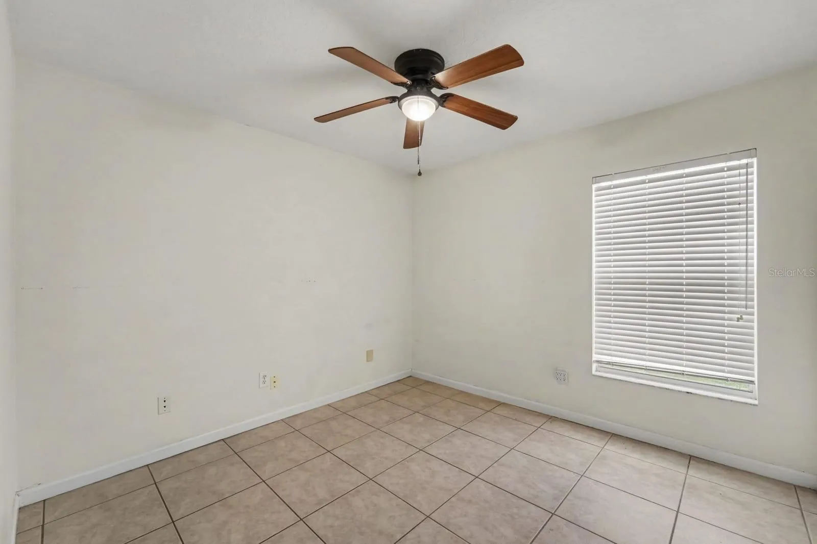 Spacious Bedroom with Ceiling Fan, Large Window &amp; Neutral Color Palette