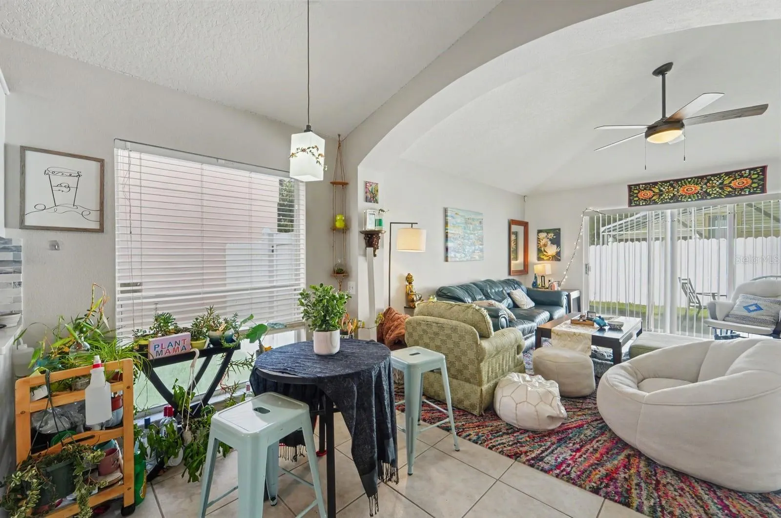 Bright great room with cathedral ceiling, abundant natural light, and multiple seating zones