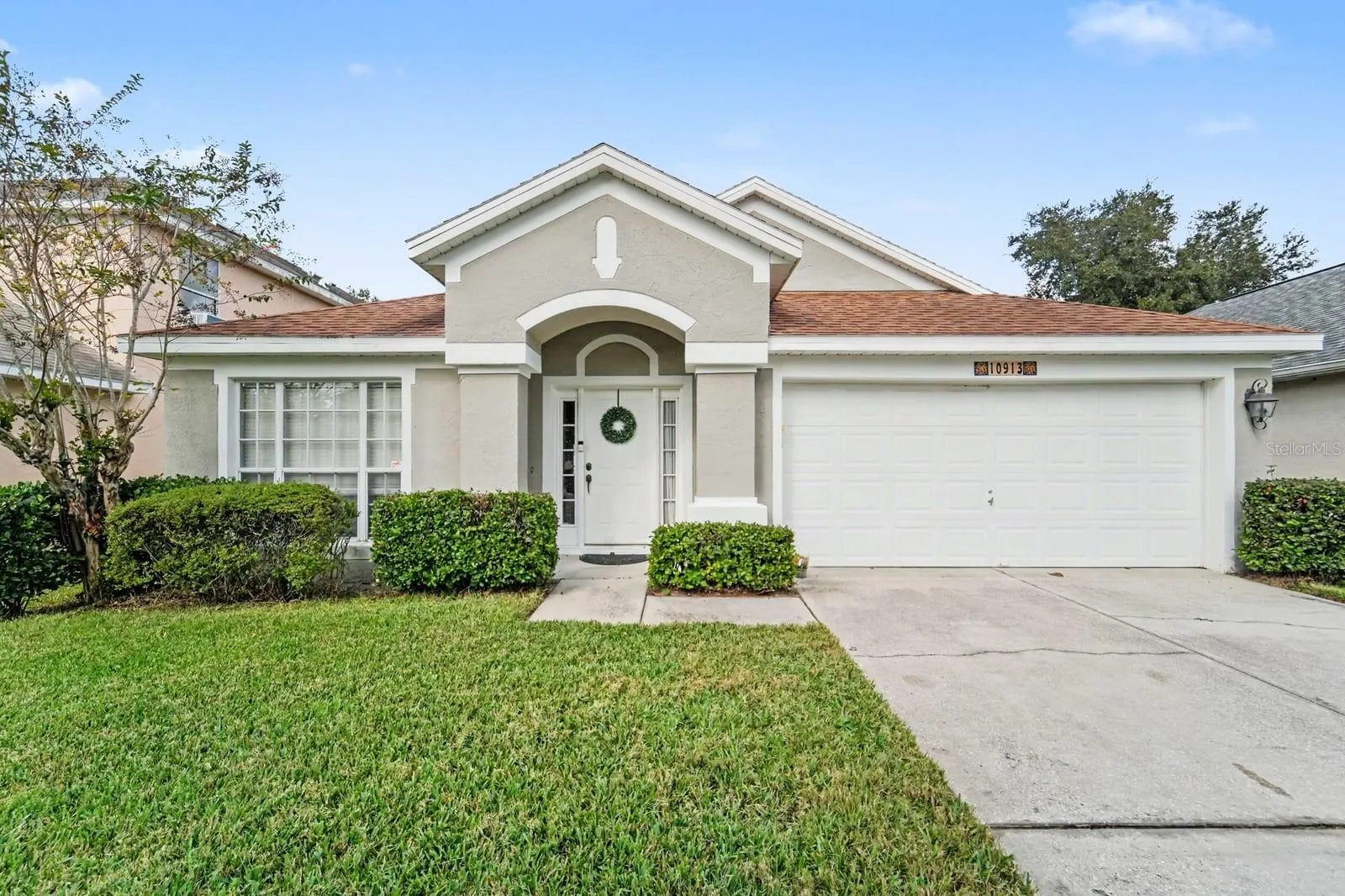 Charming single-story home with clean white exterior and welcoming entry portico