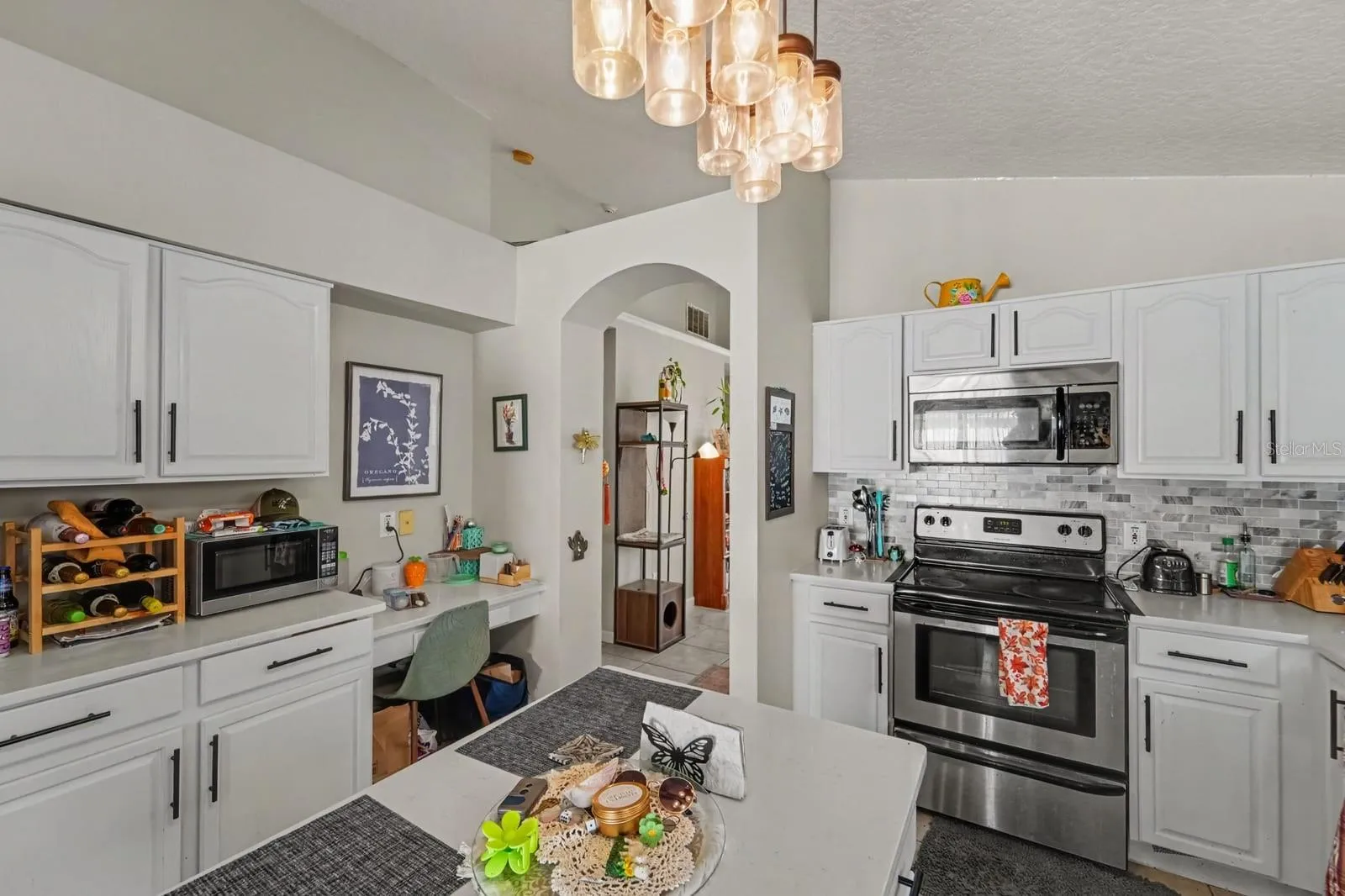 Chef's Kitchen with White Cabinetry, Stainless Steel Appliances &amp; Island Workspace