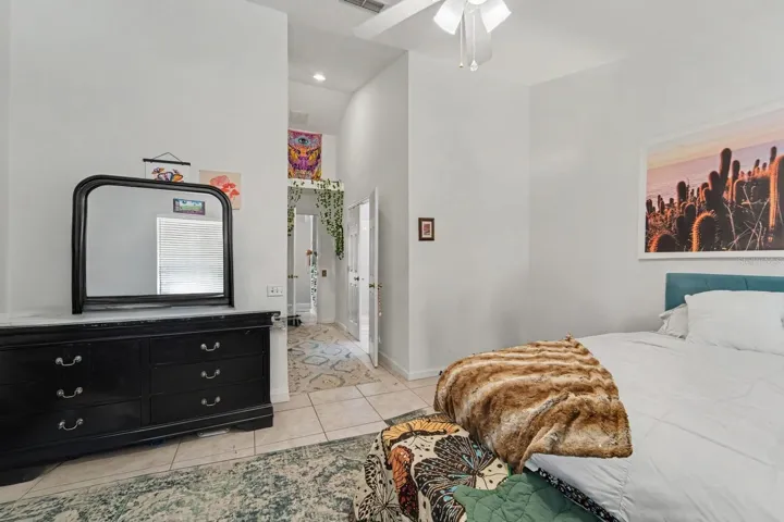 Spacious Master Bedroom with Teal Headboard, Black Furniture, and Walk-in Closet Space