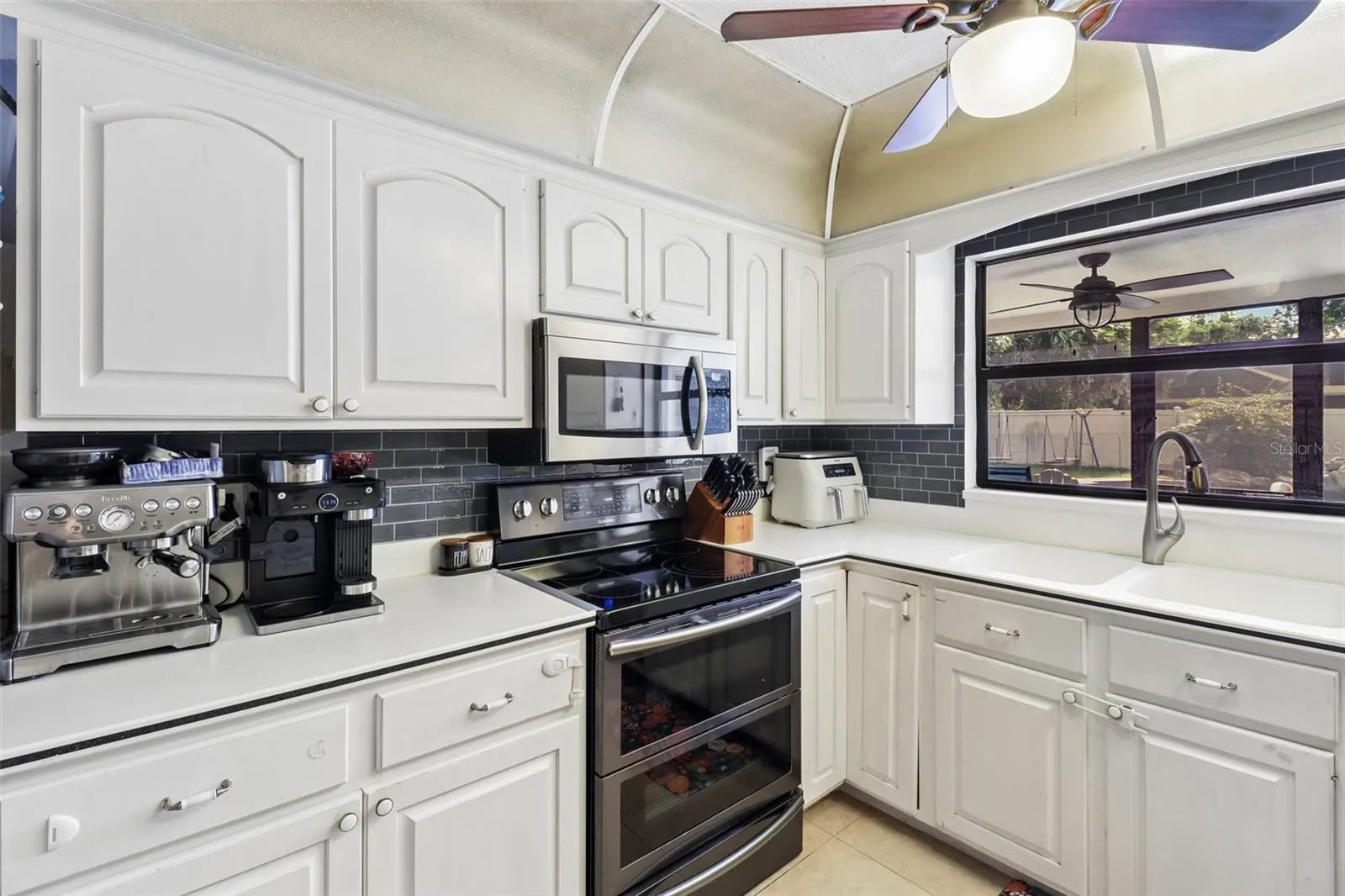 Stainless steel appliances, tiled backsplash.