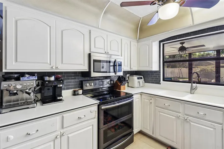 Stainless steel appliances, tiled backsplash.