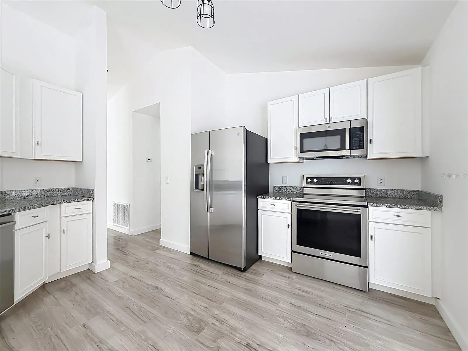 Stainless steel appliances elevate the bright kitchen.