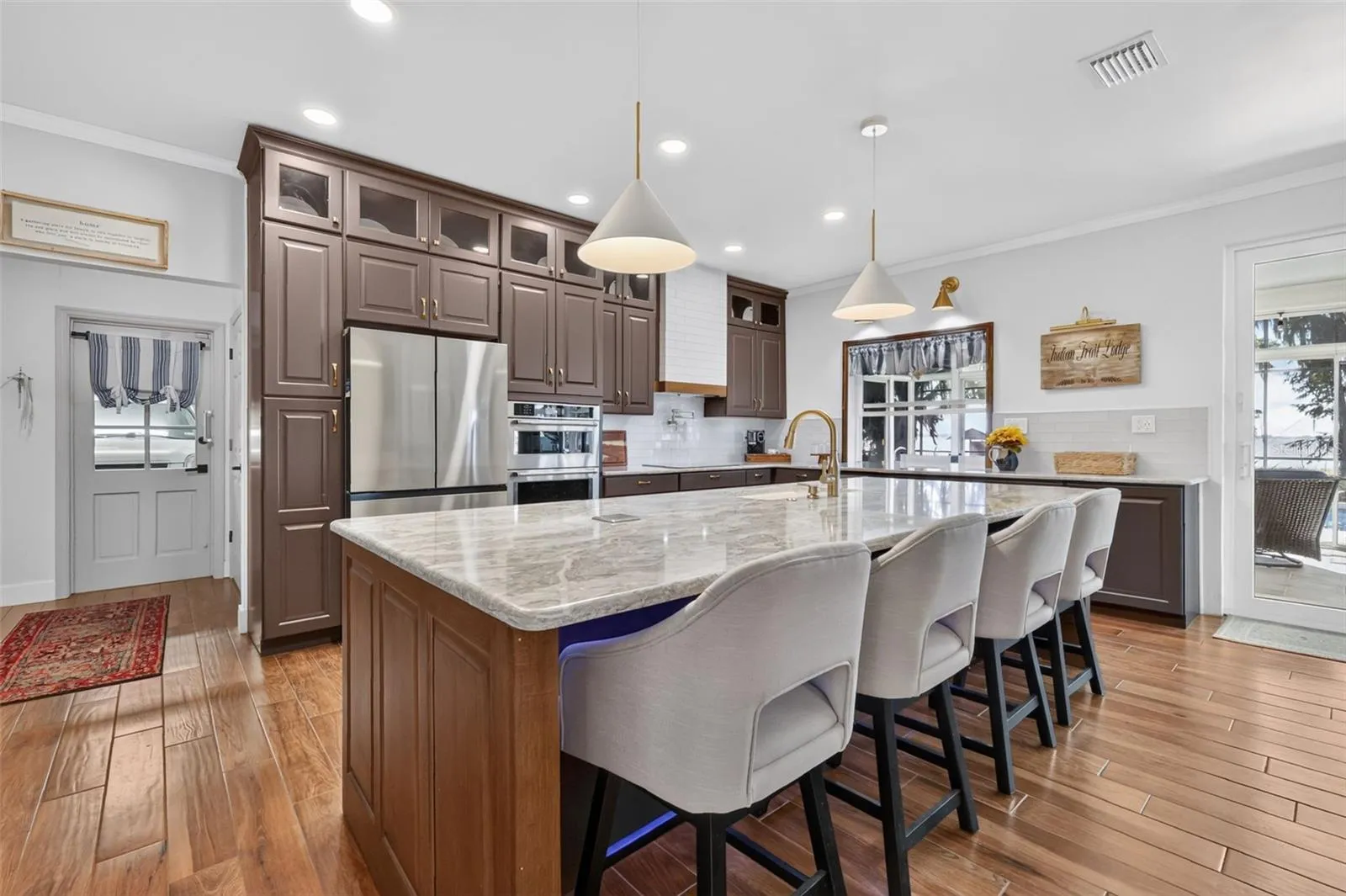 Beautifully appointed kitchen with Quartz countertops, custom cabinetry, and elevated features. Entry to the garage and laundry to the left
