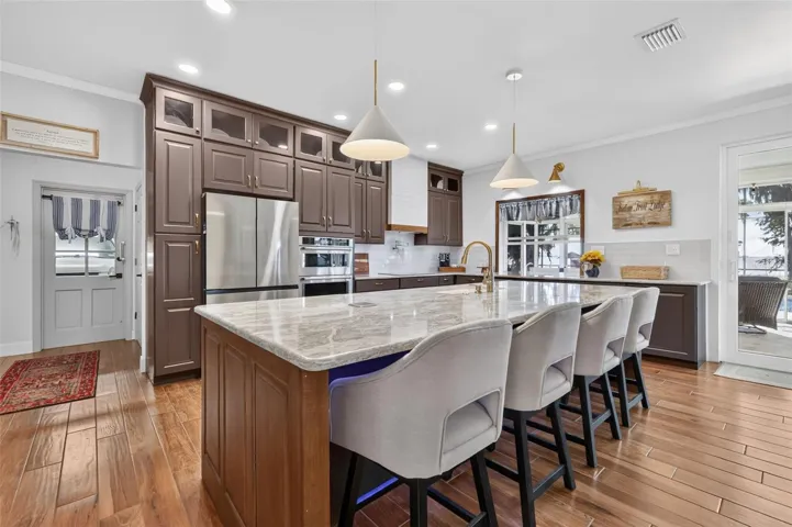 Beautifully appointed kitchen with Quartz countertops, custom cabinetry, and elevated features. Entry to the garage and laundry to the left