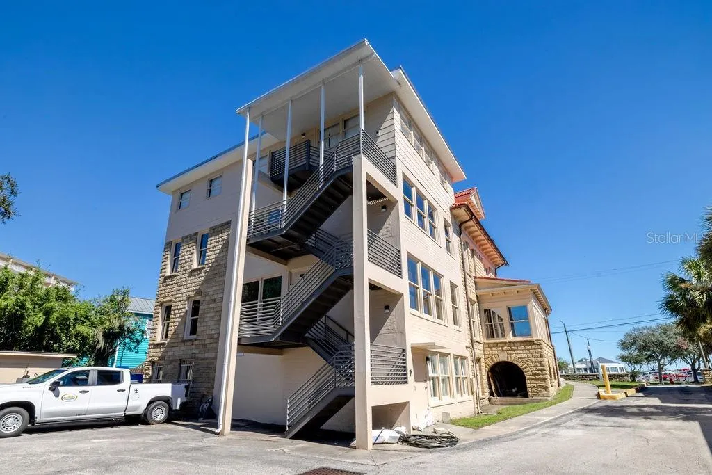 Newly constructed block and metal fire escape spanning the back of the main building.