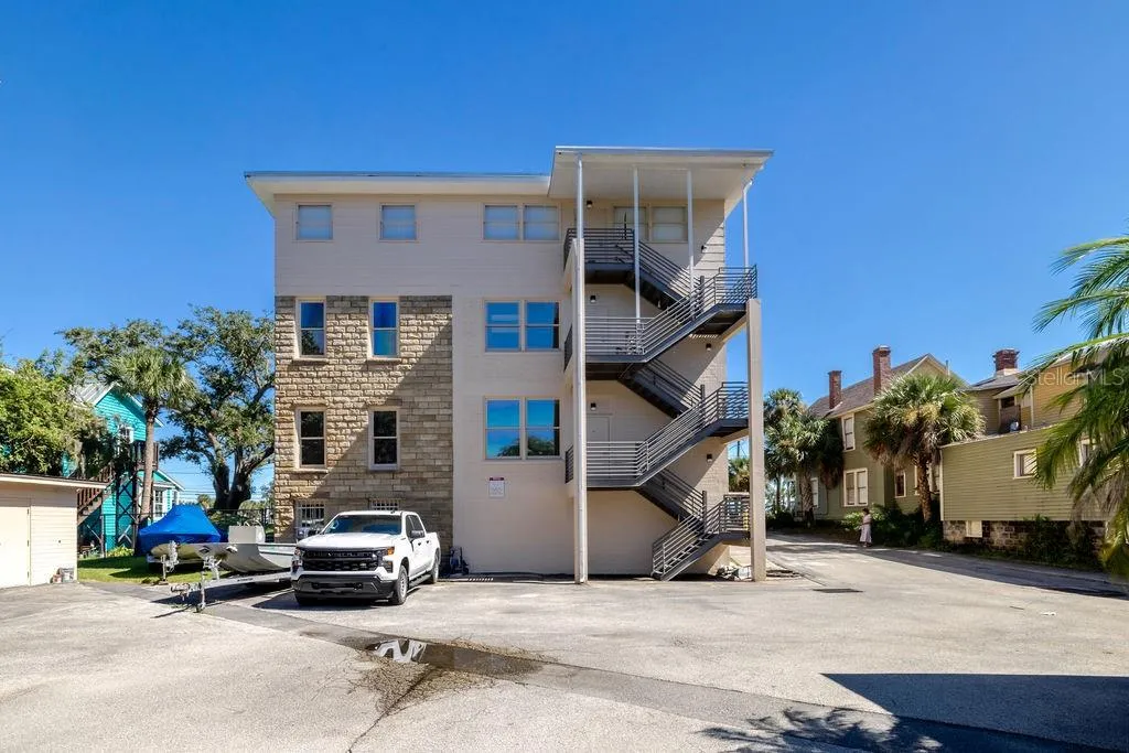 Back of building from the West, highlighting newly constructed block and metal fire escape. spanning all 3 floors.