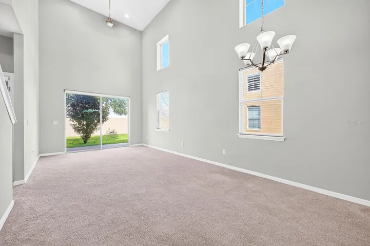 Two-story windows fill the Living/Dining Room with NATURAL LIGHT, while sliding glass doors extend the living space outdoors.