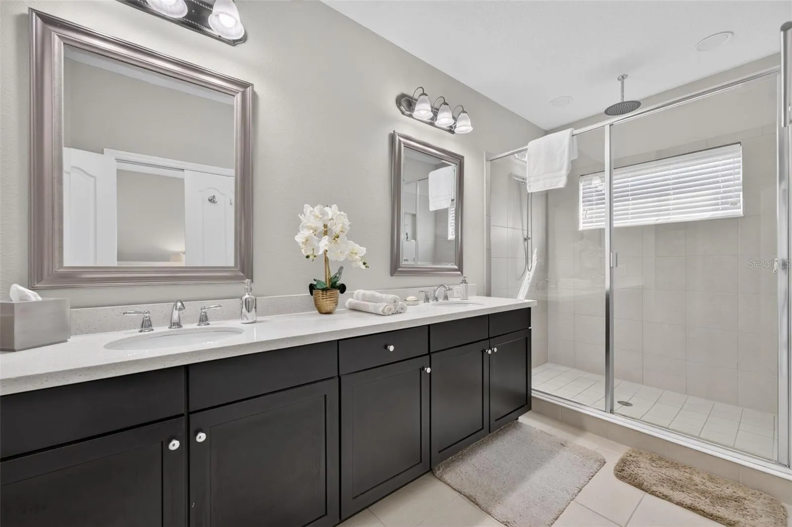 Primary Bathroom features stone counters, tall cabinetry, 2 sinks and an oversized shower