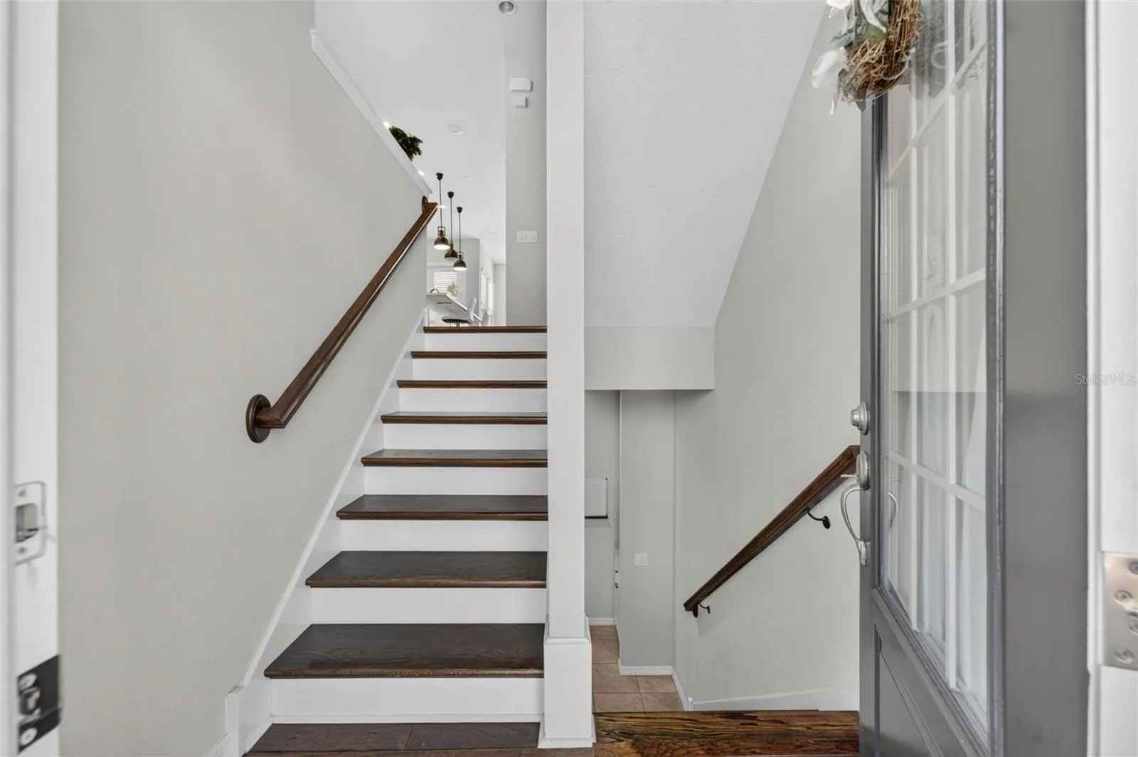Stairwell upon entry; covered with hardwood flooring on all 3 stairways; short flight up goes to main living area; one short flight down there's a bedroom, full bath and garage entry. Top level has 2 Bedrooms, 2 full baths and a laundry room