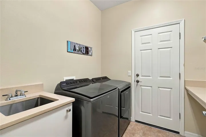Inside laundry room with 2024 washer and dryer