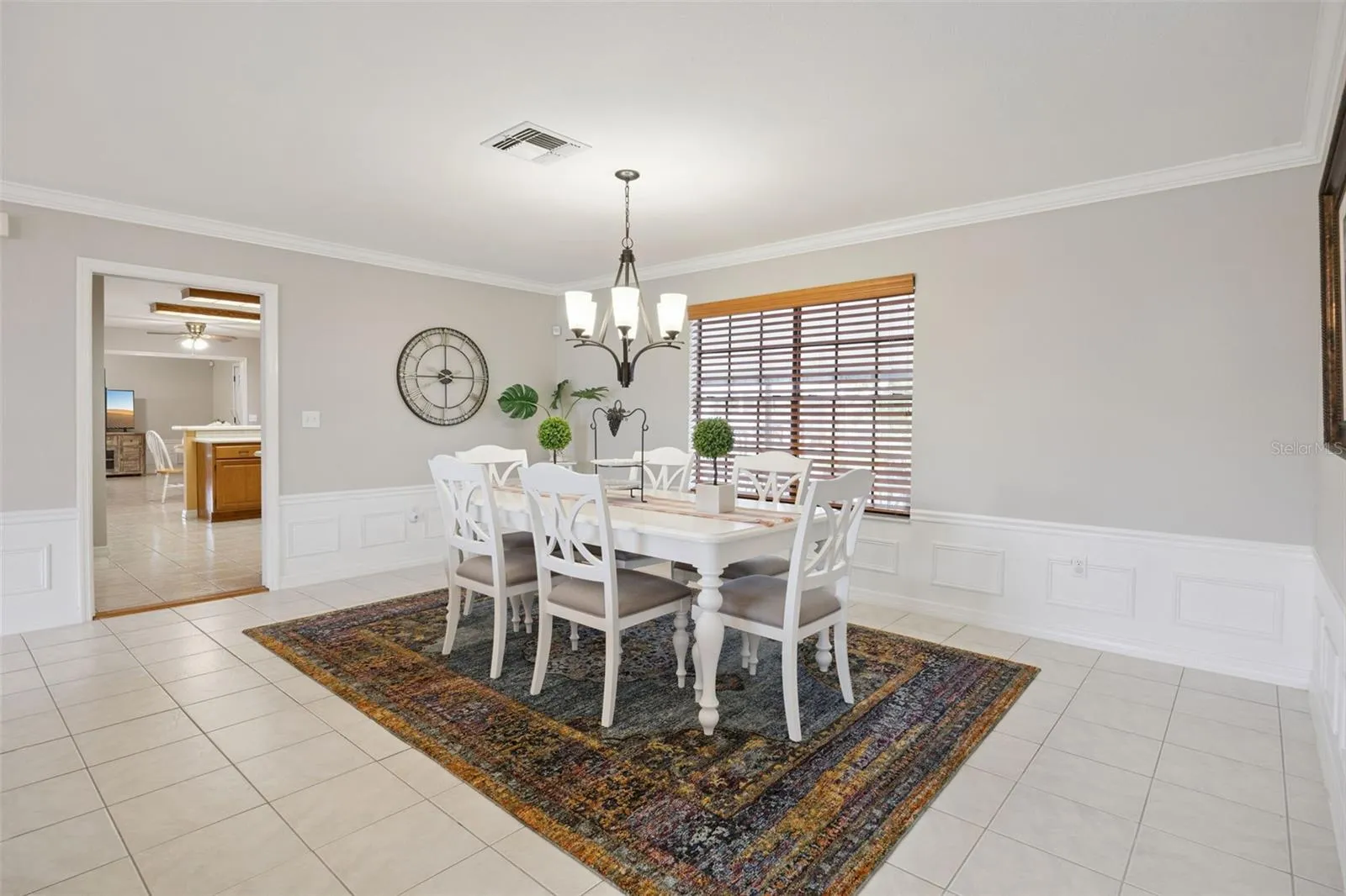 Formal Dining Alternate View: Spacious formal dining room highlighted by detailed wall molding, bright natural light, and convenient access to adjacent living spaces.