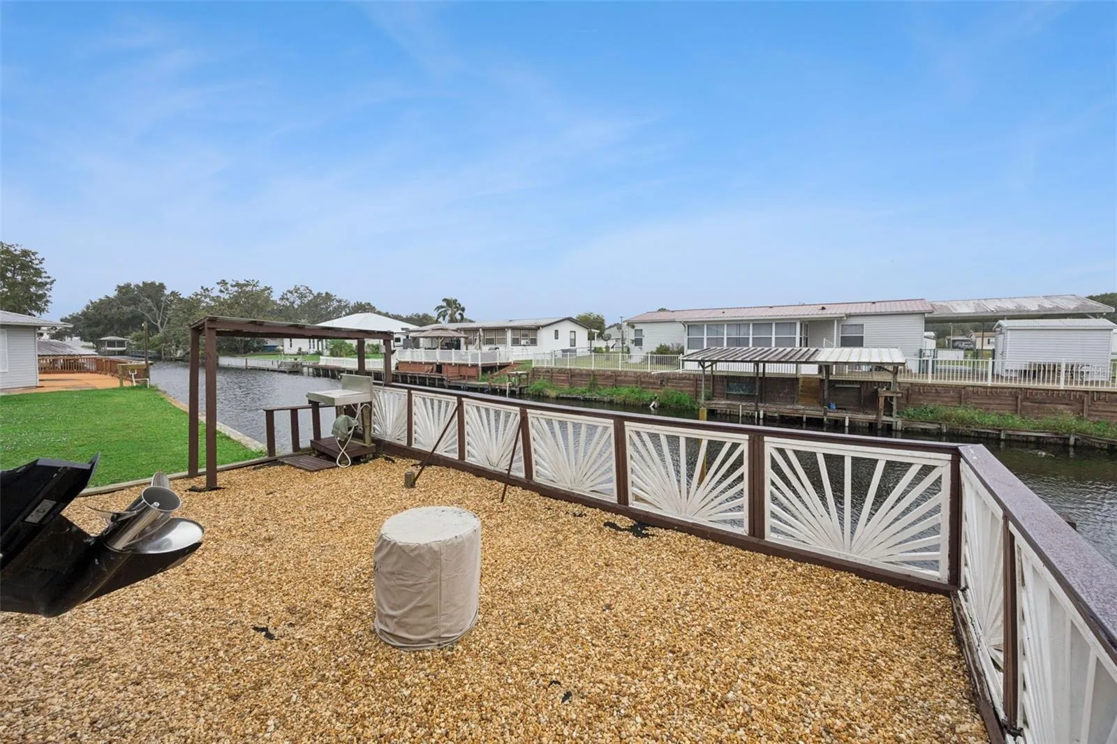 Gravel Waterfront Patio Deck: Spacious low-maintenance gravel patio area enclosed by decorative railings right by the water