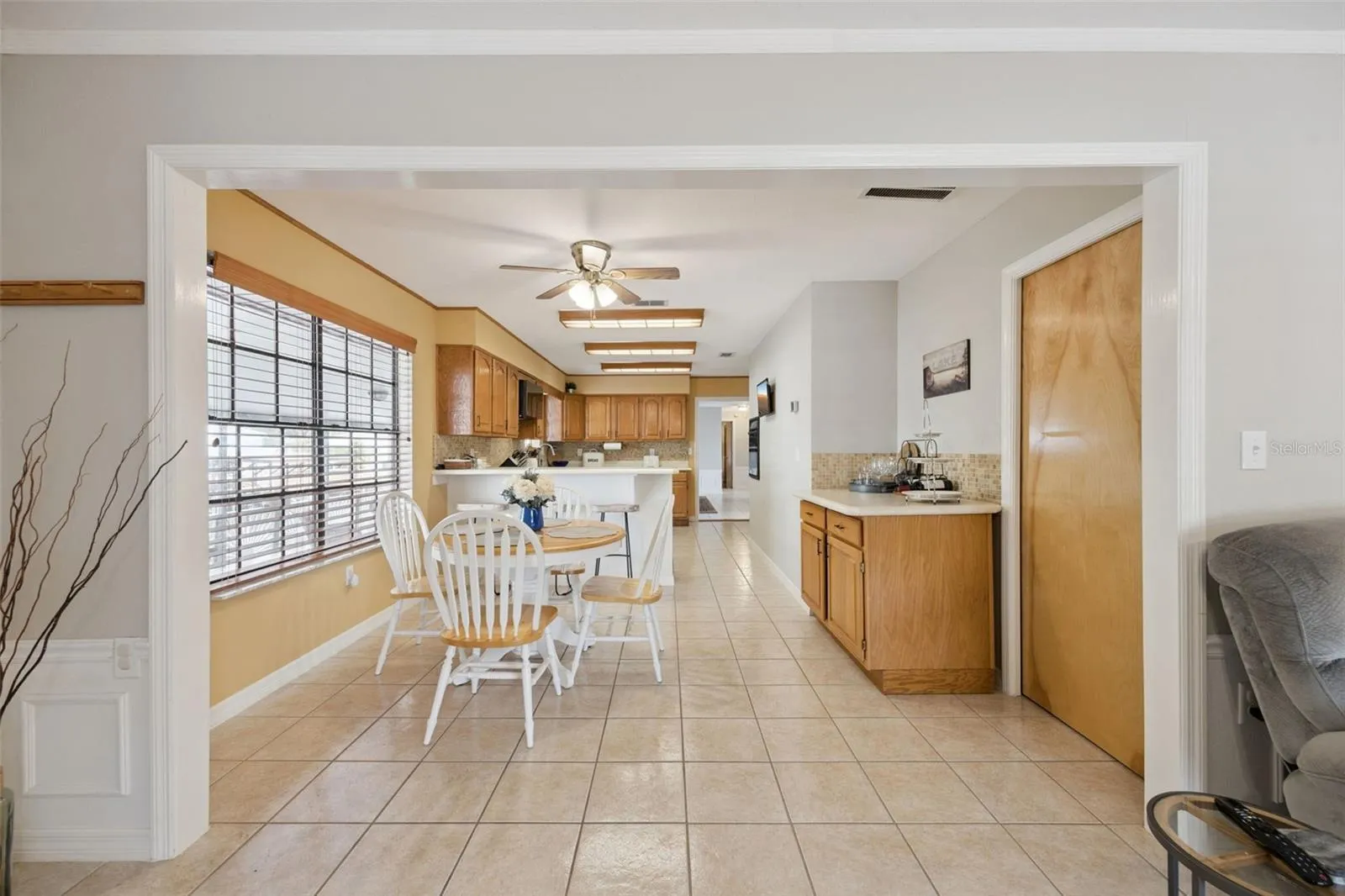 Hallway & Dinette Corridor: Bright view looking past the casual dining nook into the functional kitchen and adjacent hall storage space.