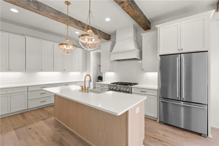 This spacious kitchen offers a large island, bright countertops, and modern appliances perfect for culinary endeavors.
