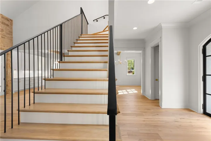 Elegant hardwood flooring flows seamlessly throughout this inviting home, featuring a grand staircase.