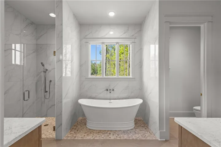 This serene bathroom offers a luxurious soaking tub and a spacious walk-in shower.