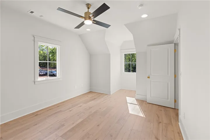Bright and airy room with polished hardwood floors and abundant natural light.