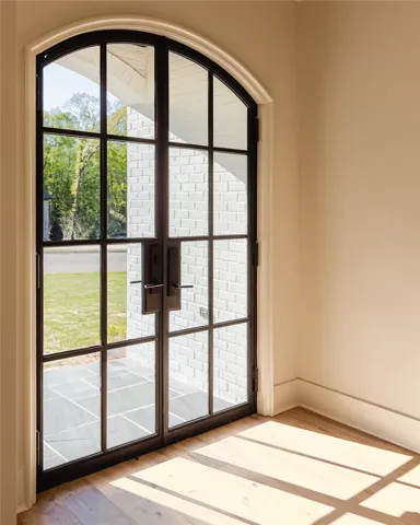This entry features a grand arched doorway, welcoming abundant natural light.