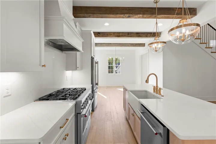This sleek kitchen features wooden beams, modern appliances, and an expansive island.