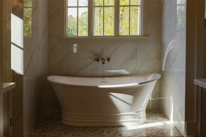 This tranquil bathroom features a luxurious soaking tub, offering a peaceful retreat amidst natural light.