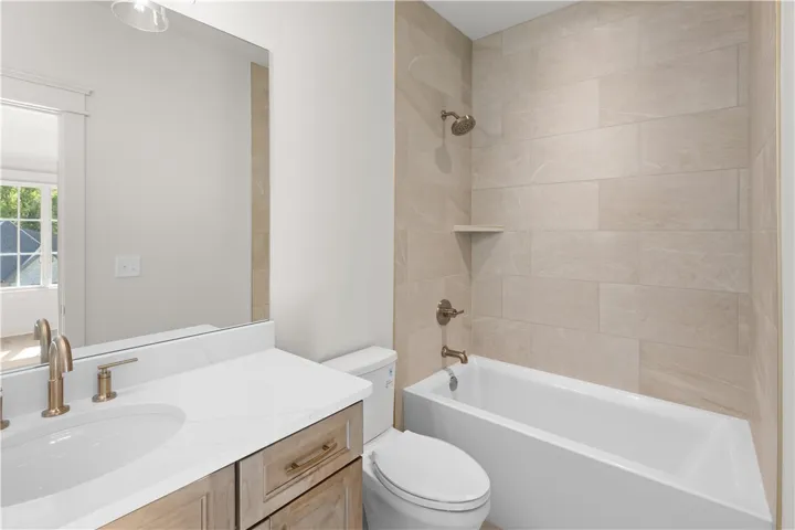 This bathroom features a sleek vanity, modern fixtures, and a refreshing shower tub combination.
