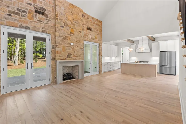 This expansive space merges living and cooking, featuring a soaring ceiling and a beautiful fireplace.