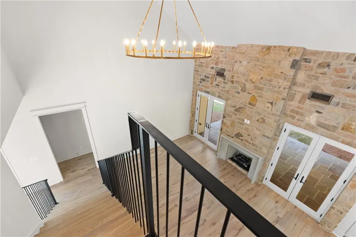 This living area features a grand stone fireplace and dual French doors leading to outdoor spaces.