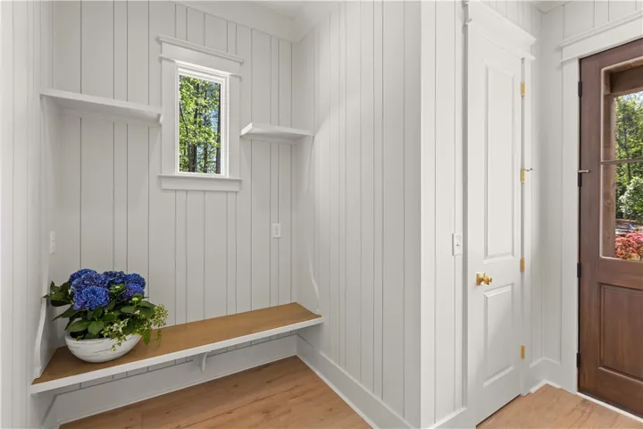 This inviting mudroom offers practical storage and a glimpse of nature through its charming window.