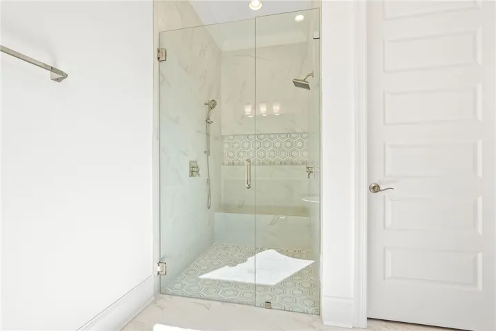 This sleek shower features elegant tile work and a convenient built-in bench.
