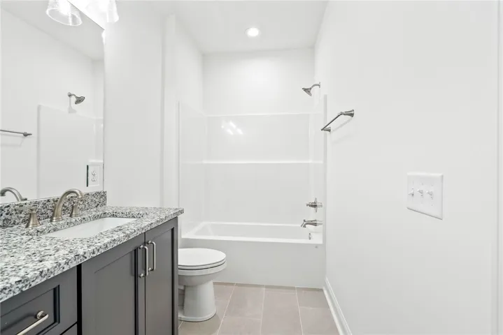 This bathroom features a sleek vanity, contemporary fixtures, and a bright, functional design.