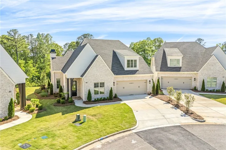 This charming residence features a well-manicured lawn and a spacious driveway leading to the garage.