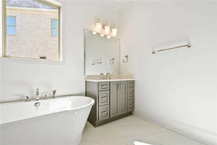 This bright bathroom features a freestanding tub and a stylish vanity, creating a serene atmosphere.