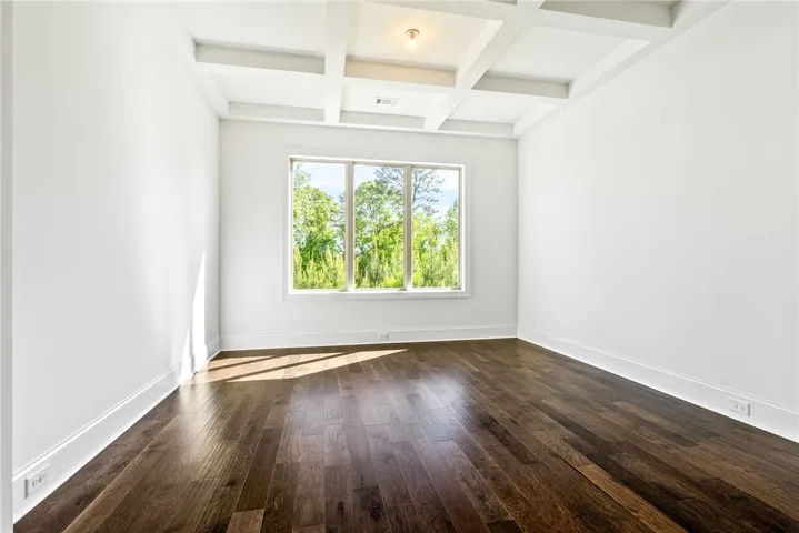 This bright room features a striking coffered ceiling and rich hardwood floors, ideal for any use.