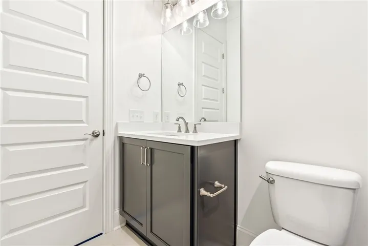 This sleek bathroom features a modern vanity and essential fixtures, offering everyday comfort.