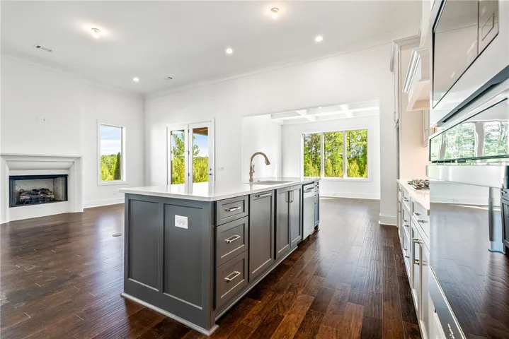 This spacious kitchen and living area features rich hardwood floors and an inviting fireplace.