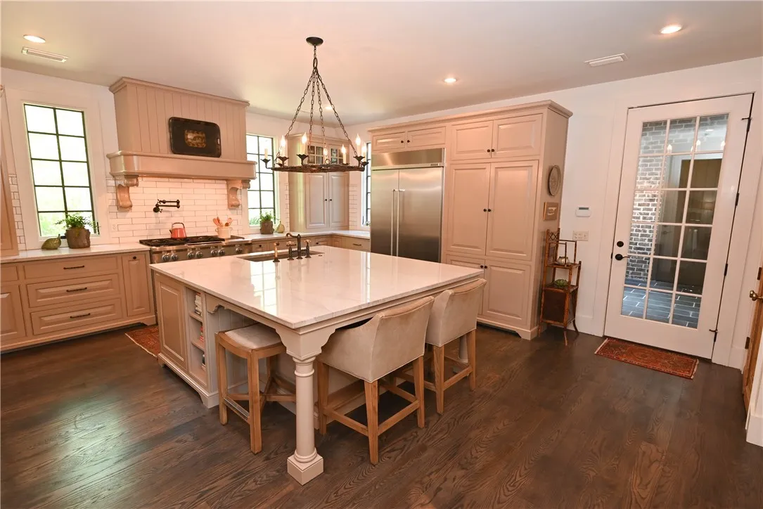The kitchen features custom cabinetry with inset doors and a center island that seats 4.