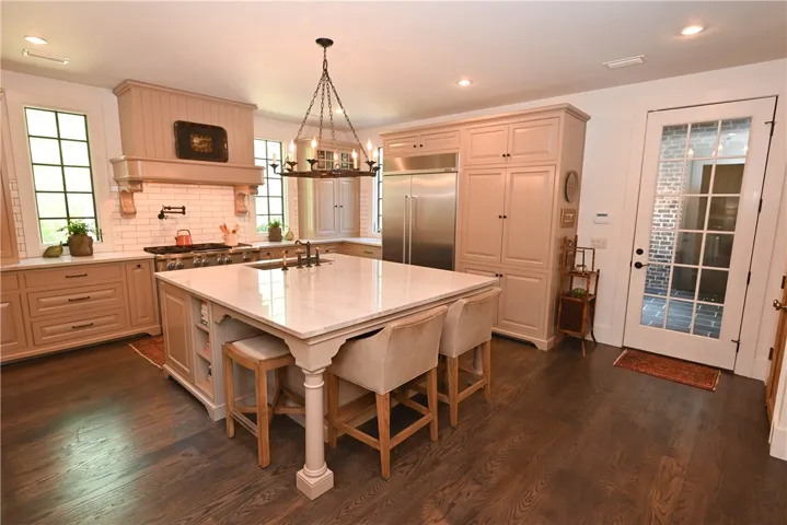 The kitchen features custom cabinetry with inset doors and a center island that seats 4.