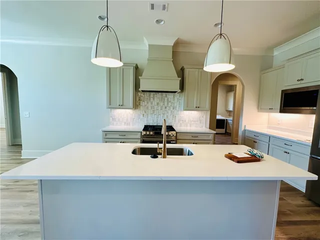 This kitchen features a central island, modern appliances, and stylish fixtures for contemporary living.