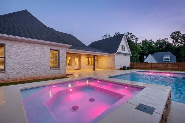 A private backyard oasis features an inviting pool and spa, perfect for evening relaxation.