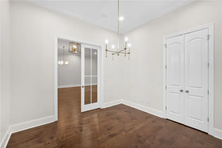 Rich hardwood floors complement the crisp white walls and elegant crown molding in this inviting space.